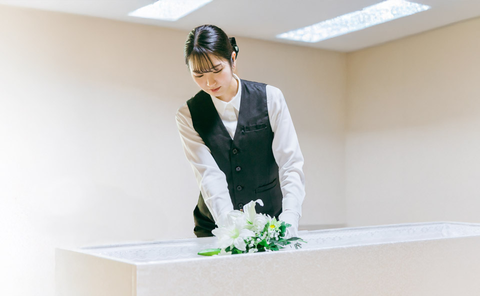 杏和セレモニーの係員が保土ヶ谷区で棺に花を整える準備をしている