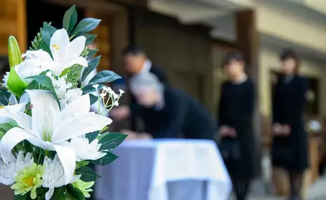 葬儀会場で白い供花が手向けられる様子を保土ヶ谷区の杏和セレモニーが案内している